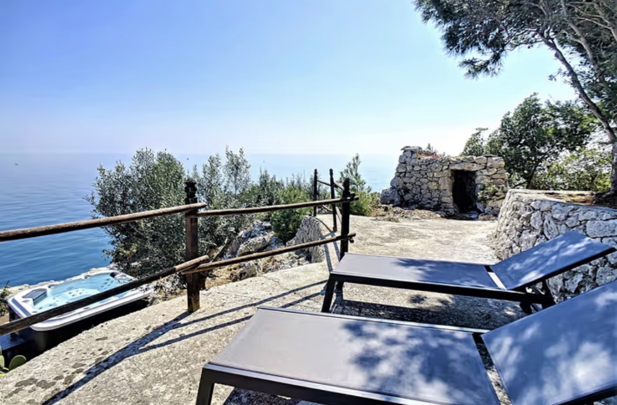 Terrasse avec transats surplombant la mer dans les Pouilles