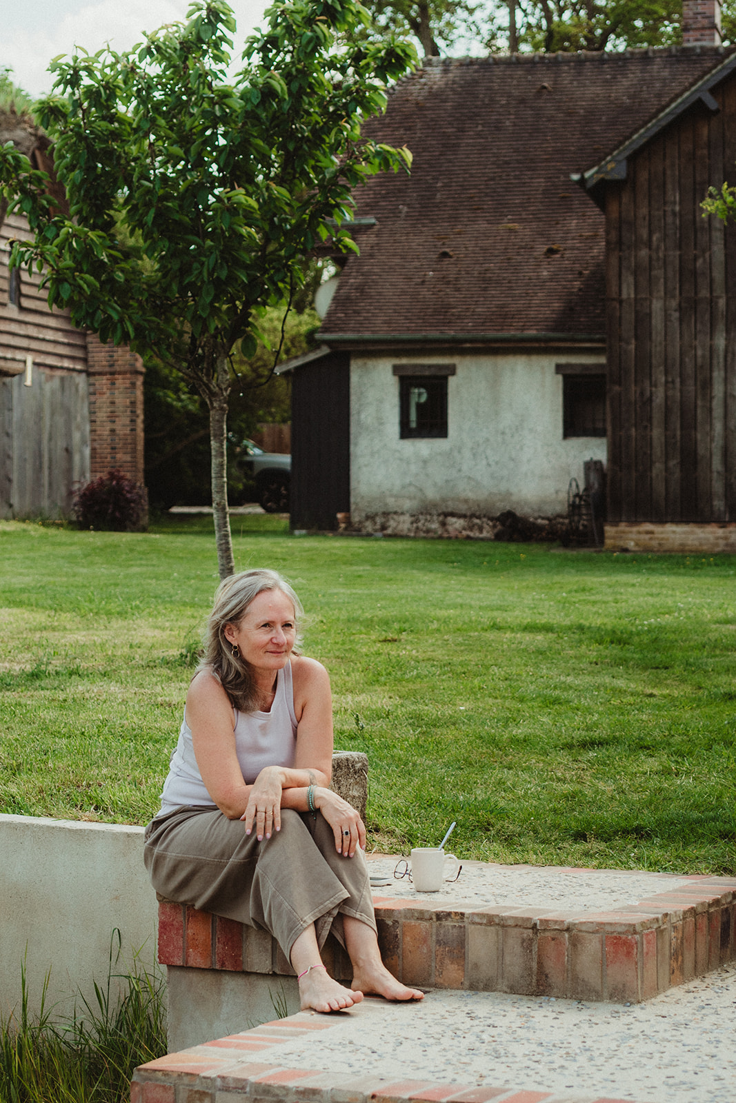 Virginie assise paisiblement dans un jardin en Normandie