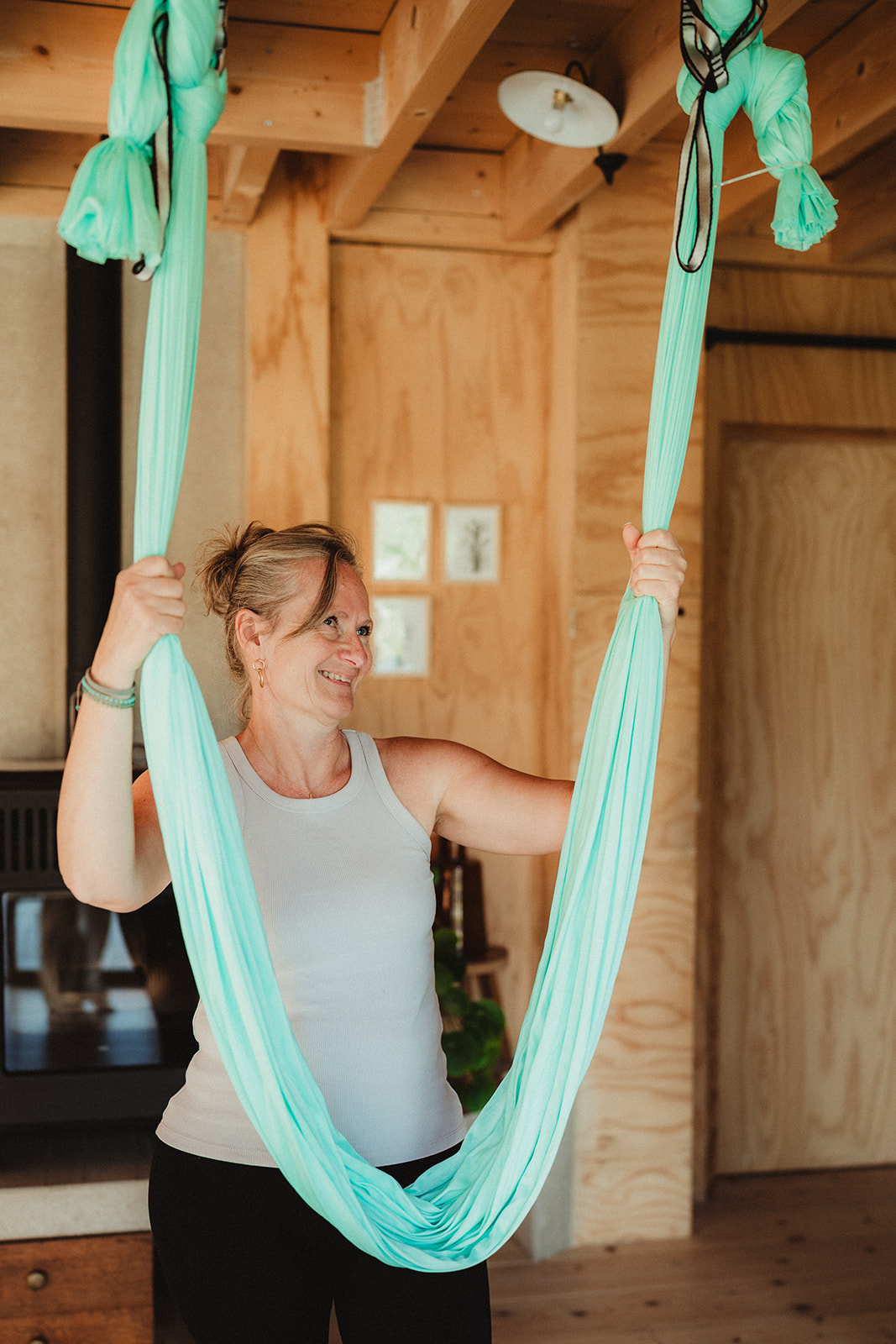 Virginie souriante tenant un hamac de yoga aérien